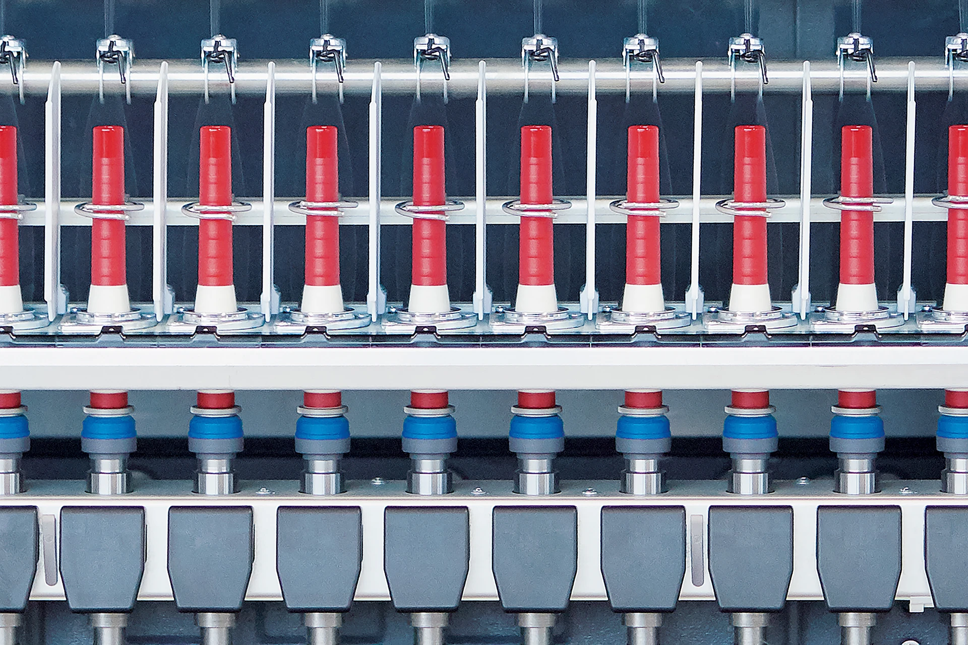 Nahaufnahme einer Zinser Kompaktspinn-Maschine mit Fokus auf den Texparts Spindeln und den hier eingesetzten Spinnfinity System