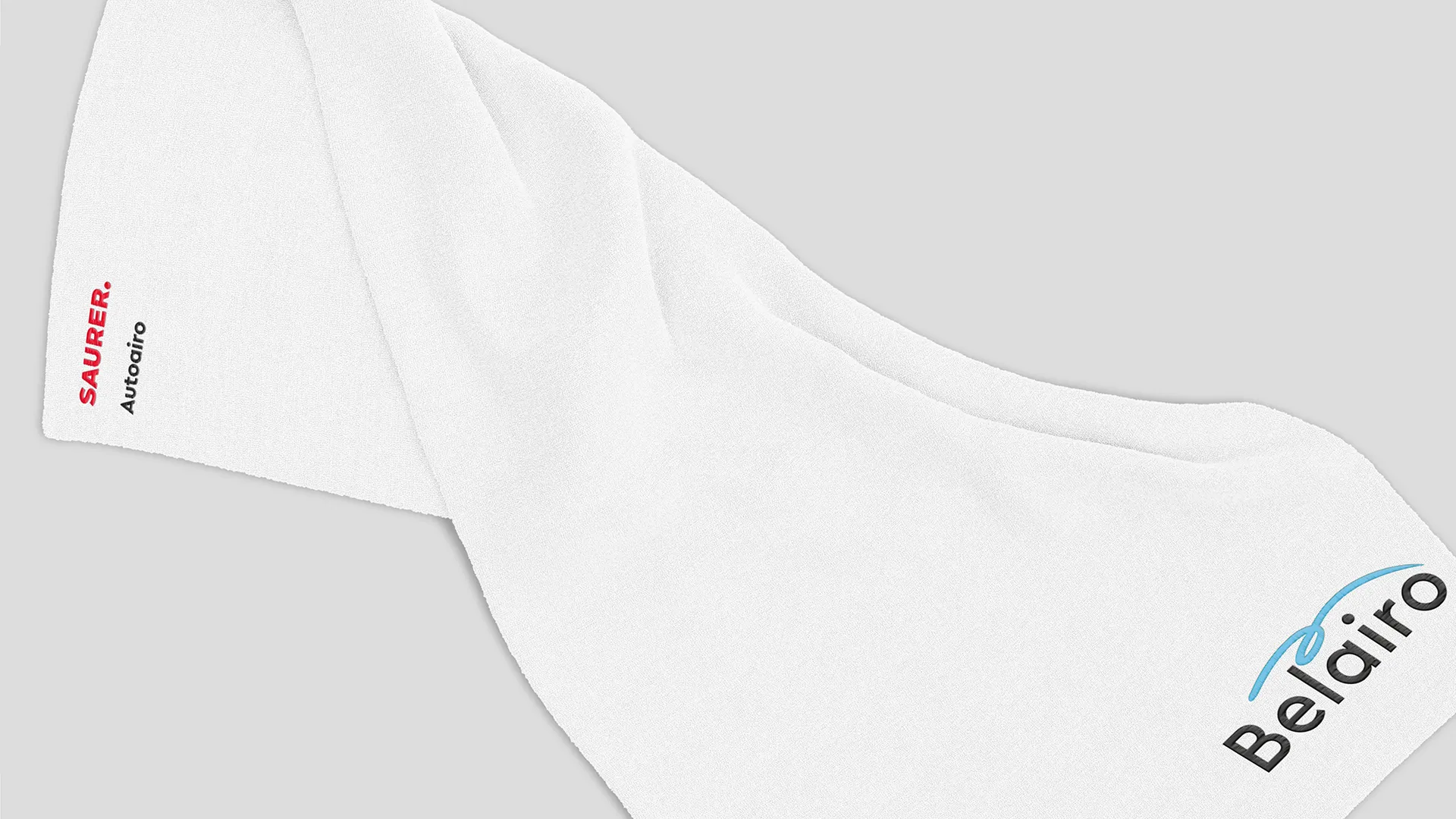 Ein weißes Frottee Badetuch mit Stickerei der Marken Saurer und Belairo